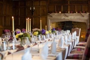 a long table in a room with candles and flowers at The Falcon Hotel in Uppingham