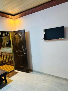 a door with a flat screen tv on a wall at YR'S Nature Farmhouse in Badlapur