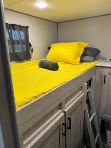a bed with a yellow comforter on top of it at Pilot Glamp in Vieques