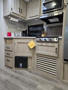 a kitchen with wooden cabinets and stainless steel appliances at Pilot Glamp in Vieques