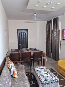 a living room with a couch and a dining room table at Friendly Service Apartment in Ghaziabad