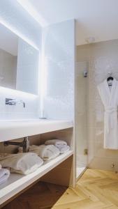 a bathroom with a sink and a mirror and towels at Hôtel le XIX in Béziers