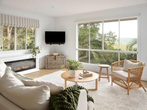 a living room with a couch and a fireplace at Oak Ridge Cottage in Maleny