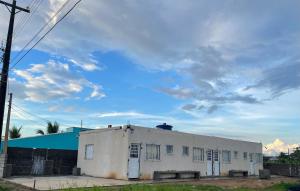 an old white building under a cloudy sky at Ape Bianck's in Ilha Comprida