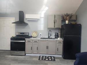 a kitchen with white cabinets and a black refrigerator at Genesis Get Away in Evergreen