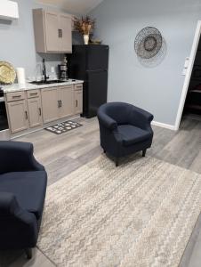 a living room with two chairs and a kitchen at Genesis Get Away in Evergreen +3 photos