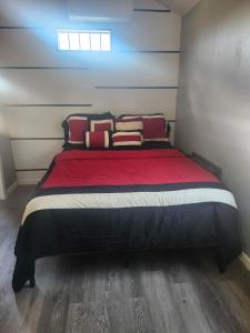 a bedroom with a bed with red sheets and pillows at Genesis Get Away in Evergreen