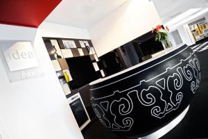 a living room with a black bench with a vase at Idea Hotel Milano Malpensa Airport in Case Nuove