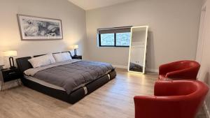 a bedroom with a bed and a red chair at The Sandpearl in Stevensville