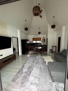 a living room with a tv and a couch and a table at ILKI 2BR Pool Villa in Ko Phangan