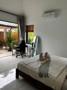a bedroom with a bed and a desk and a chair at ILKI 2BR Pool Villa in Ko Phangan +9 photos