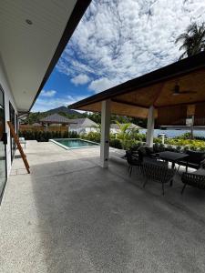 a patio with tables and chairs and a swimming pool at ILKI 2BR Pool Villa in Ko Phangan