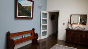 a bathroom with a mirror and a wooden dresser at Arvalee Retreat With Outdoor HotTub in Omagh