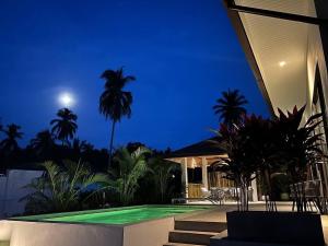 a villa with a swimming pool at night at ILKI 2BR Pool Villa in Ko Phangan