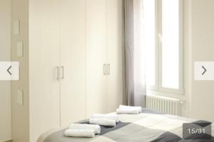 a bedroom with a bed with towels on it at Appartamento Bolzano Centro Talvera in Bolzano