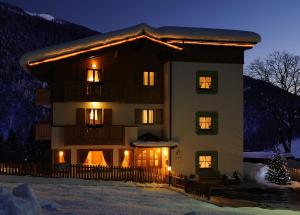 マドンナ・ディ・カンピリオにあるHotel Garnì La Soldanellaのクリスマスツリーが目の前にある大家