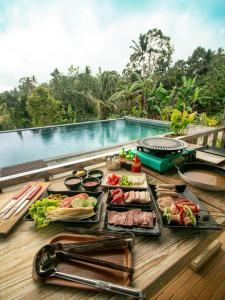a buffet of food on a table next to a pool at Mina Baturiti Hotel & Resto in Patjung