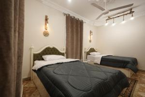 a bedroom with two beds and a ceiling at ABo ZAIN HOSTEL in Aswan