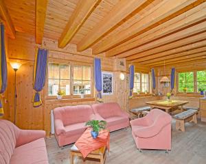 シュトゥンムにあるChalet mit Sauna und Kamin A 257.001の木造家屋のリビングルーム(ピンクの家具付)