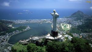 a statue of christ the redeemer on top of a mountain at Andar Alto Frente Ipanema in Rio de Janeiro