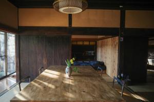 a dining room with a wooden table with a vase on it at 0site house in Hokuto