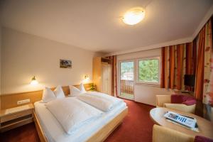 A bed or beds in a room at Hotel Garni Waldhof - Wohlfühlen am Lech