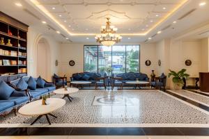 a lobby with blue furniture and a chandelier at D'Lioro Hotel & Resort in Ha Long