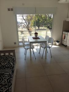 a dining room with a table and chairs and a window at Frente al Río in Paraná