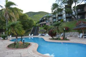 una gran piscina con palmeras y edificios en Hotel Del Dique en Coronel Moldes
