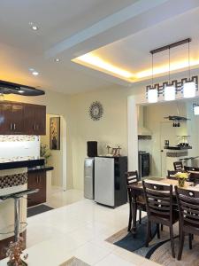 a kitchen and dining room with a table and a refrigerator at Eusel's Place Butuan in Butuan