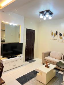 a living room with a television and a couch at Eusel's Place Butuan in Butuan