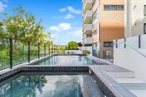 a swimming pool on the balcony of a building at Direct Collective - Rhythm on Beach in Maroochydore