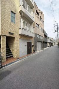 an empty street in front of a building at 旅館ほのか in Osaka
