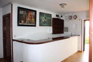 a bar in a room with two pictures on the wall at Hostal Tamarindos in Matalascañas