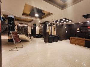 a large room with a staircase and a bar at Hotel The Siwan International in Siwān
