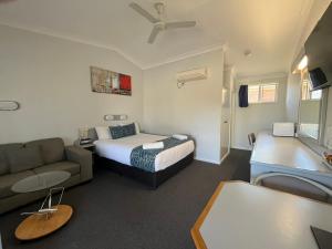 a hotel room with a bed and a couch and a bed and a living room at Rest Point Motor Inn in Glen Innes +27 photos