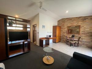 a living room with a couch and a dining room at Rest Point Motor Inn in Glen Innes