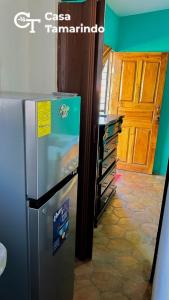 a refrigerator in a kitchen next to a door at Casa Tamarindo in Las Peñitas