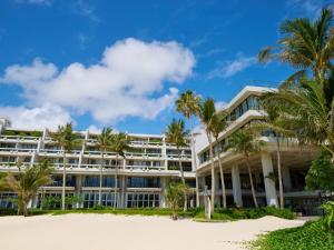 a building on the beach with palm trees at Palace In Moon Beach in Onna