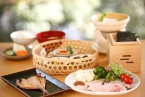 a table with a plate of food and a basket of food at Mifuneyama Rakuen Hotel in Takeo