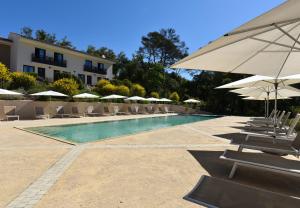 - une piscine avec des chaises longues et des parasols dans l'établissement Mercure Brignoles Golf de Barbaroux & Spa, à Brignoles