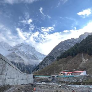 a train on a bridge with mountains in the background at Ilhaan Resort Sonamarg in Sonāmarg