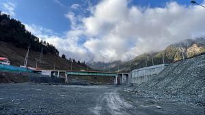 a bridge over a dirt road on a mountain at Ilhaan Resort Sonamarg in Sonāmarg