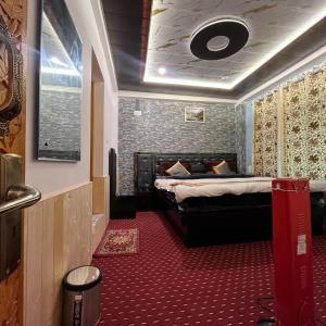 a bedroom with a bed and a red carpet at Ilhaan Resort Sonamarg in Sonāmarg