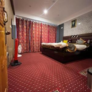 a bedroom with two beds and red carpet at Ilhaan Resort Sonamarg in Sonāmarg +7 photos