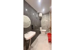 a bathroom with a sink and a toilet at Hotel Raas Grand in Sachendi