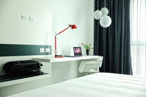 a hotel room with a bed and a desk with a laptop at Idea Hotel Milano Malpensa Airport in Case Nuove