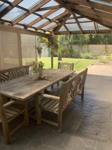 a wooden picnic table under a wooden pergola at G & R Beach Cottage in Warnbro