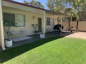 a screened in porch with chairs and a hammock at G & R Beach Cottage in Warnbro