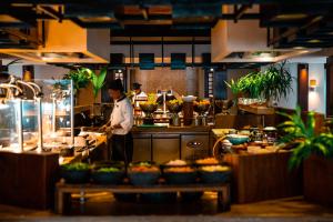 a chef standing in a kitchen preparing food at Ayada Maldives - Complimentary domestic transfer for 2 Adults for stays of 7 nights or more, valid for stay dates from May through the end of September 2026 in Vaadhoo